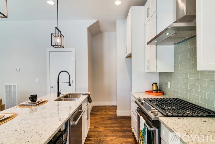 A kitchen with a white counter top and a stove top oven.