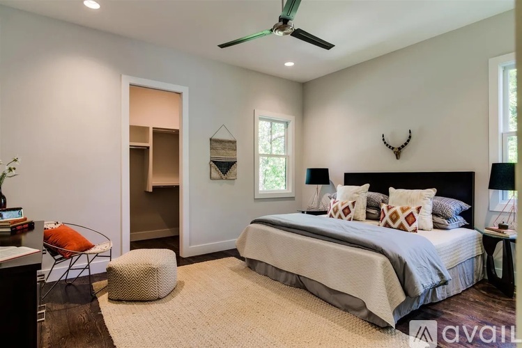A bedroom with a bed, a chair, and a ceiling fan.