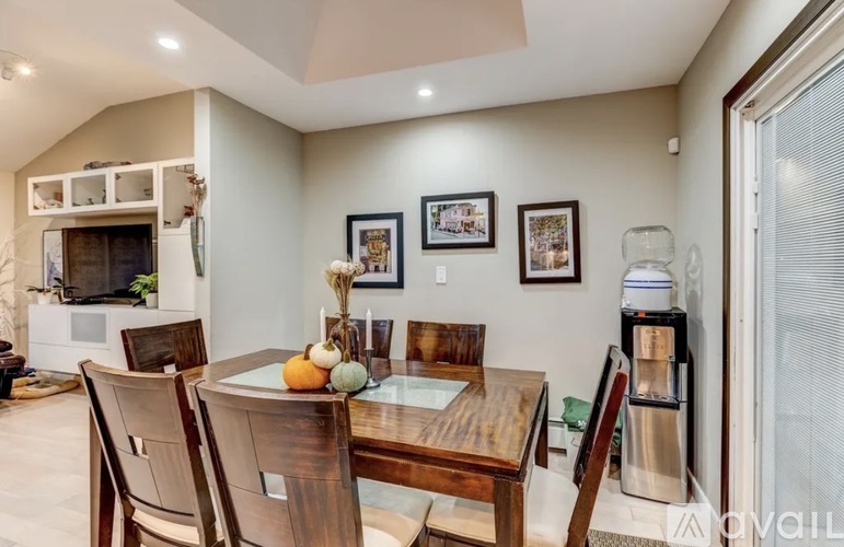 A dining room with a wooden table and chairs.