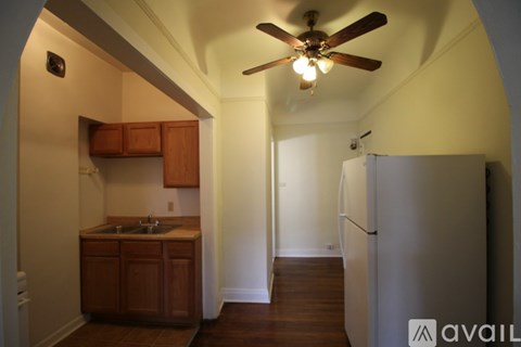 A kitchen with a refrigerator and a ceiling fan.