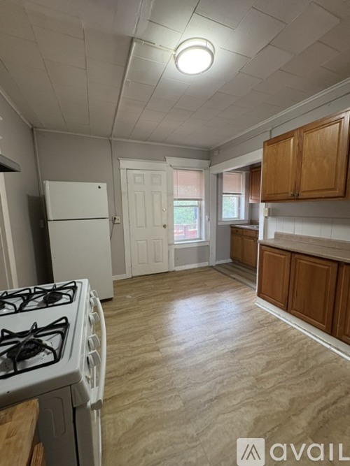A kitchen with a white gas stove and wooden cabinets.