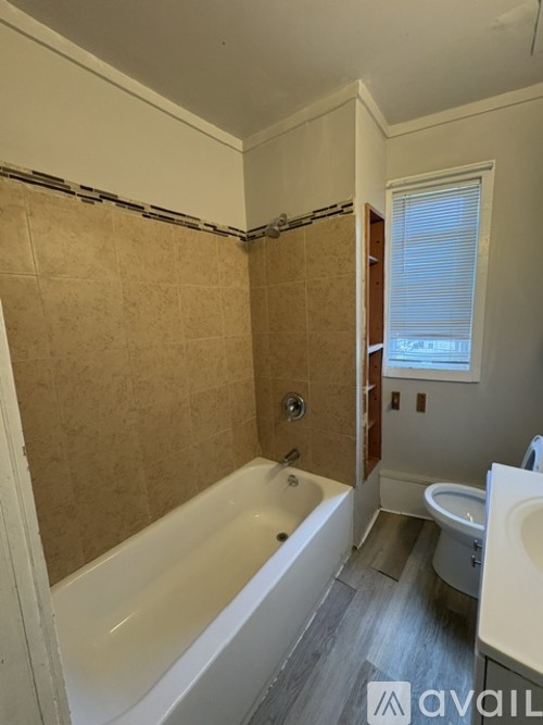 A bathroom with a tub, toilet, and sink.