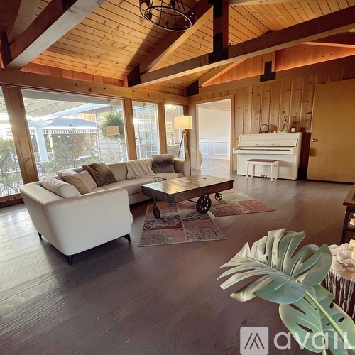 A living room with a white sofa and a wooden ceiling.