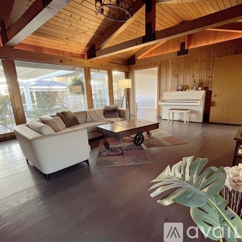 A living room with a white sofa and a wooden ceiling.