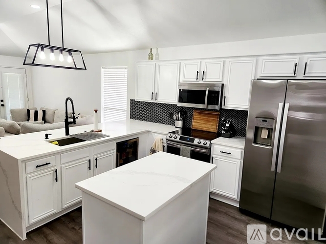 A modern kitchen with white cabinets and a large island.