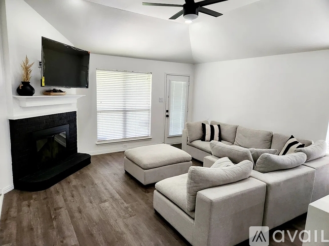 A living room with a fireplace and a television on the wall.