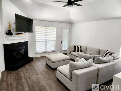 A living room with a fireplace and a television on the wall.
