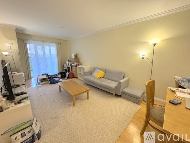 A living room with a grey sofa, a wooden coffee table, and a television.
