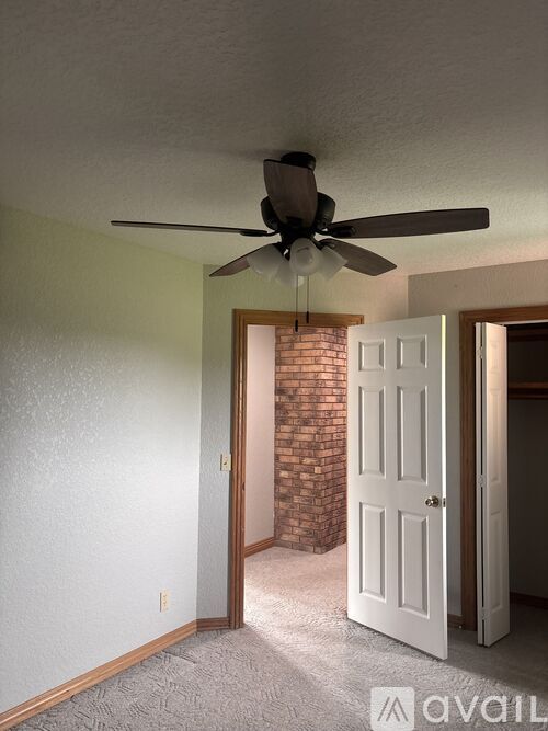 A room with a ceiling fan and a door.