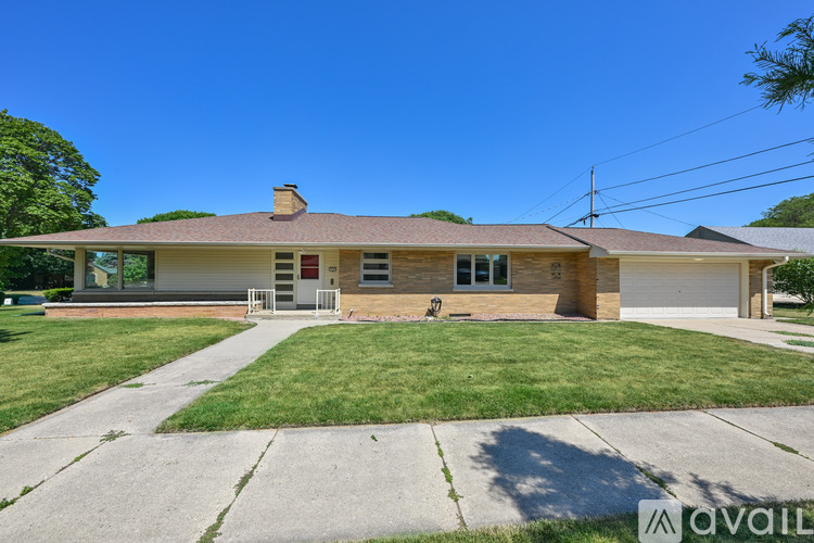 A house with a brown roof and a white garage door is for sale.
