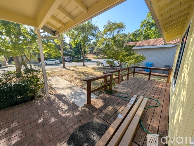 A patio with a table and chairs is covered by a roof.