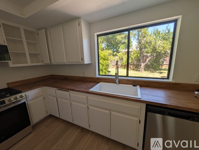 A kitchen with white cabinets and a stainless steel dishwasher.