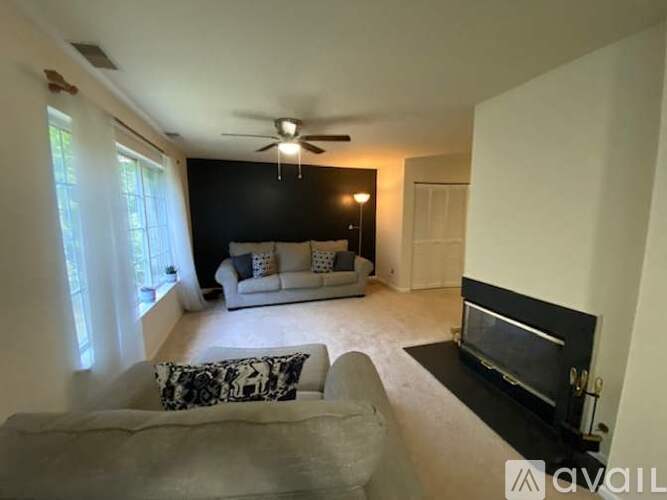 A living room with a grey couch and a black fireplace.