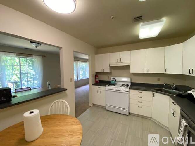 A kitchen with white cabinets and a wooden table.