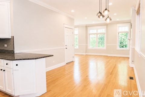 A kitchen with white cabinets and a black countertop is available for rent.