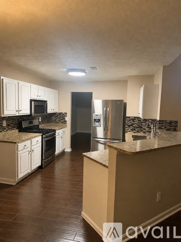 A kitchen with a refrigerator and a microwave.