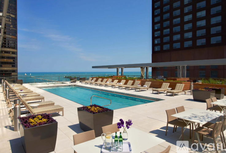 A pool area with chairs and a table with flowers on it.