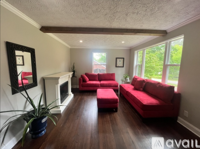 A living room with red couches and a fireplace.