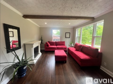 A living room with red couches and a fireplace.