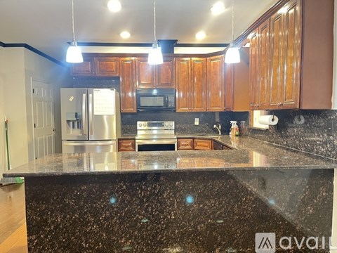 A kitchen with wooden cabinets and a granite countertop.