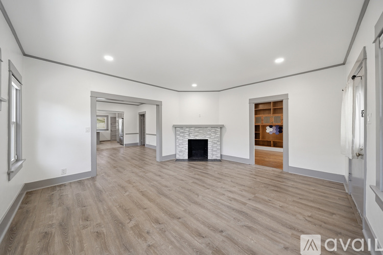 A spacious living room with a fireplace and hardwood flooring.