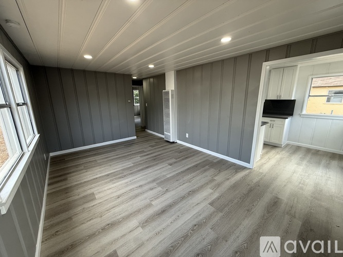 A room with wooden flooring and grey walls.