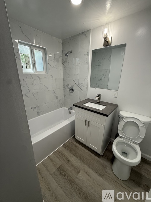 A bathroom with a toilet, sink, and bathtub.