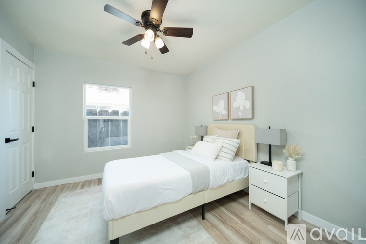 A bedroom with a bed, nightstand, and a ceiling fan.