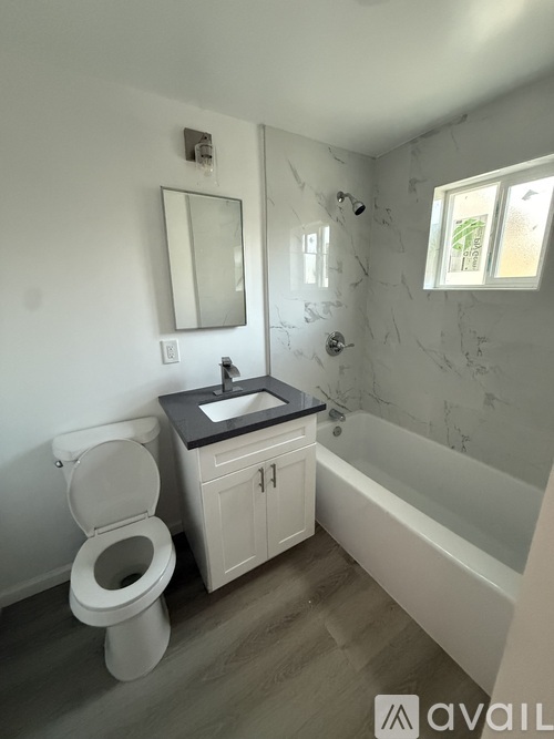 A bathroom with a toilet, sink, and bathtub.