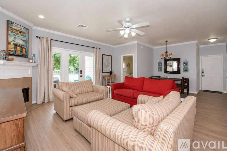 A living room with a red couch and striped couches.