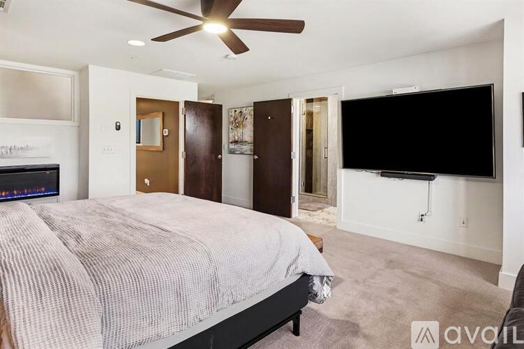 A bedroom with a large bed and a flat screen TV mounted on the wall.