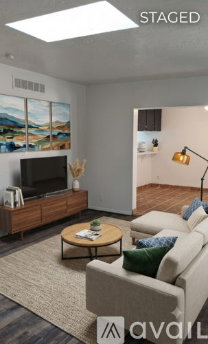 A living room with a couch, a coffee table, and a television.