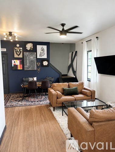 A living room with a brown leather couch and a glass coffee table.