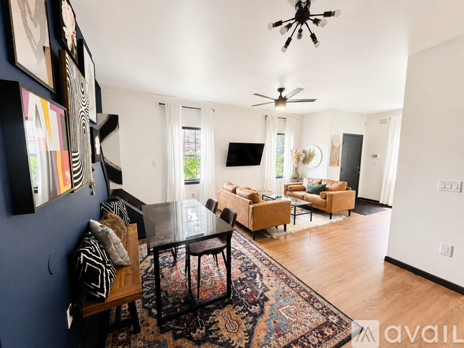 A living room with a rug, a sofa, a table and a TV.
