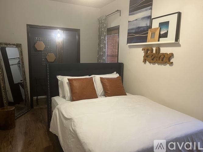 A bedroom with a bed, a dresser, and a mirror.