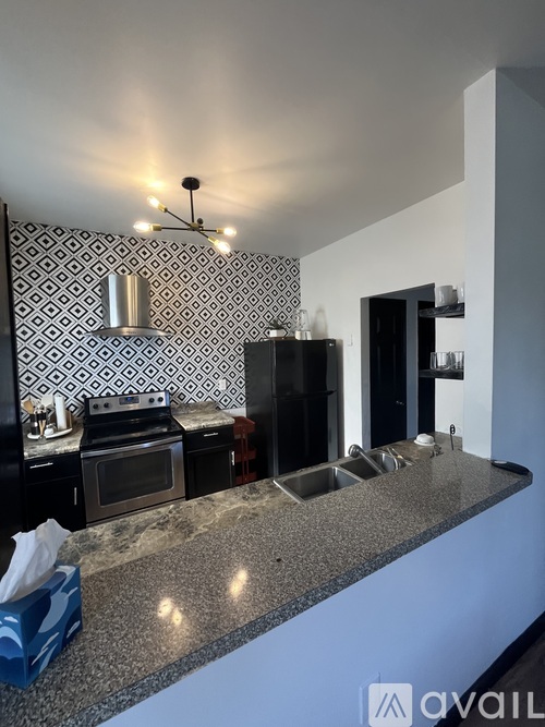 A kitchen with a granite countertop and a patterned backsplash.