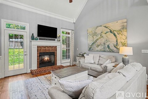 A living room with a fireplace and a painting on the wall.