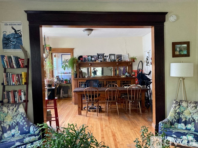 A living room with a couch, chairs, and a bookshelf.