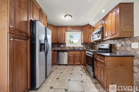 A kitchen with wooden cabinets and a black countertop.