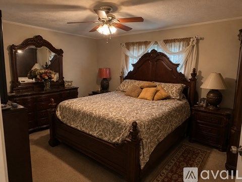 A bedroom with a large bed and a dresser with a mirror.
