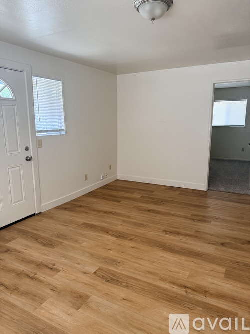 A room with wooden flooring and white walls.