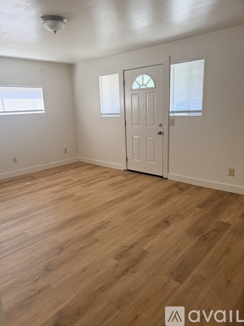 A room with wooden flooring and a white door.