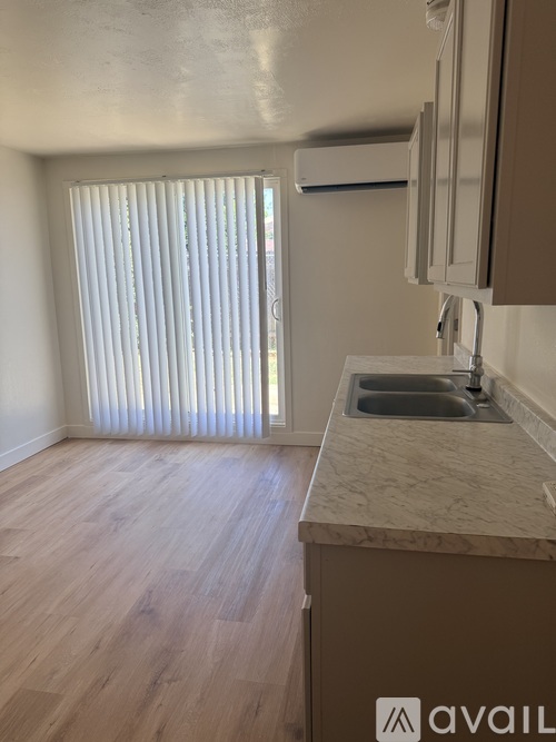 A kitchen with a sink and a window with blinds.