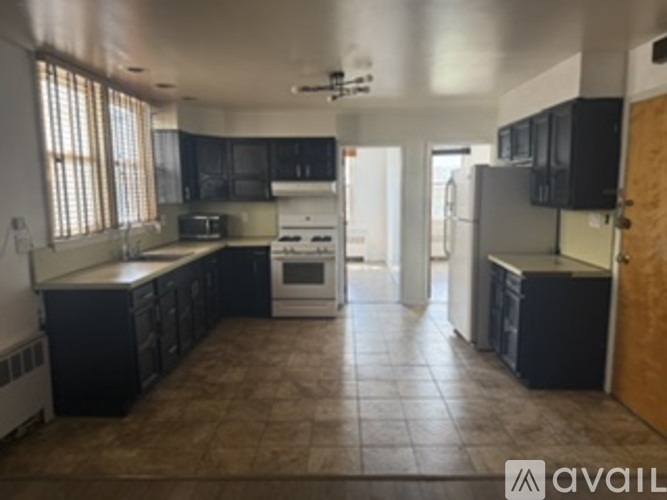 A kitchen with black cabinets and a white stove top oven.