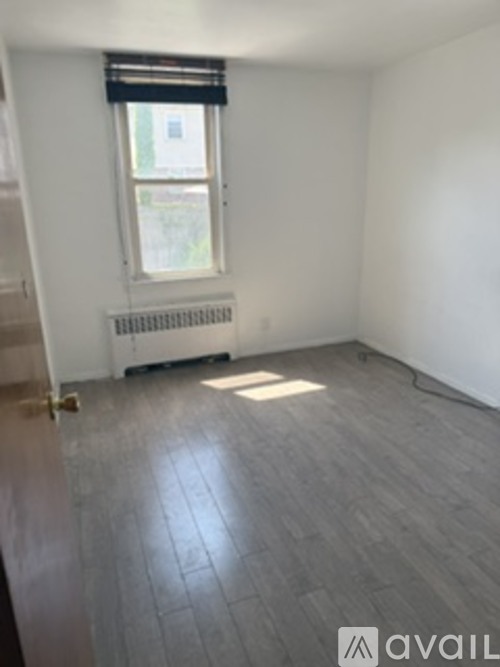 A room with a window and a radiator on the floor.