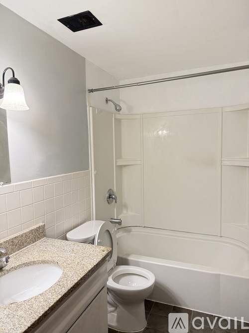 A bathroom with a toilet, sink, and bathtub.
