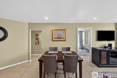 A dining room with a wooden table and chairs, a television, and a painting on the wall.