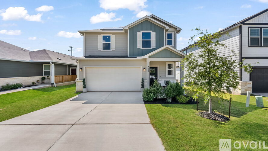 A house with a grey roof and a blue trim is for sale.