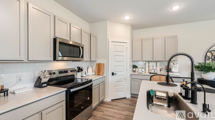 A kitchen with a black oven and a black microwave.