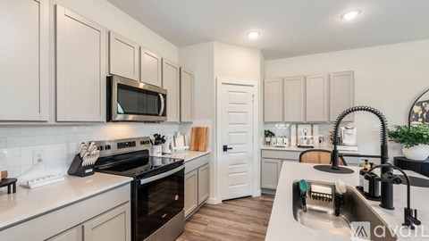 A kitchen with a black oven and a black microwave.